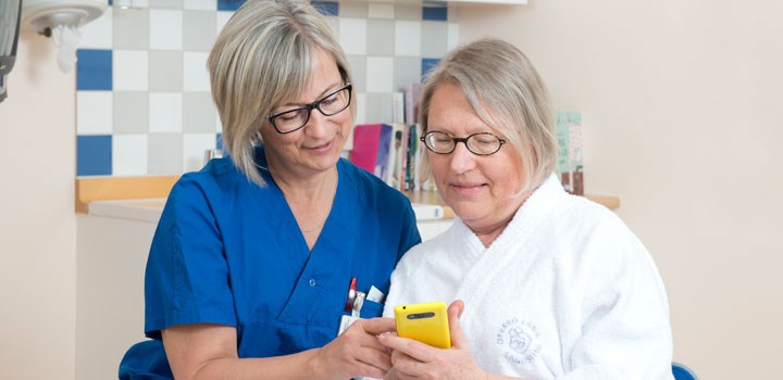 Sjuksköterska visar mobilappen Rapp för en patient.