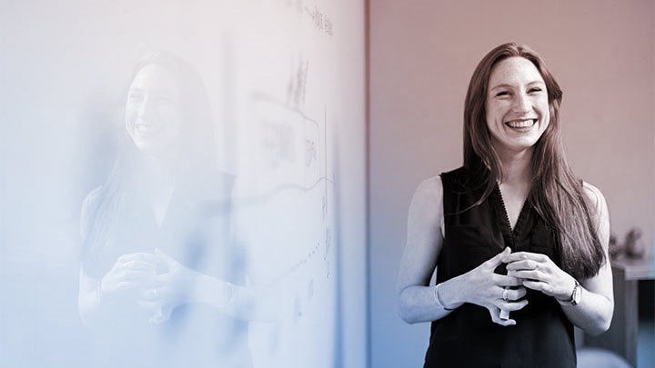 Person giving a presentation beside a whiteboard.