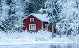 A red cottage in a winter landscape.