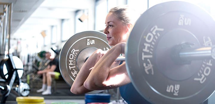 Student lyfter vikter på gym