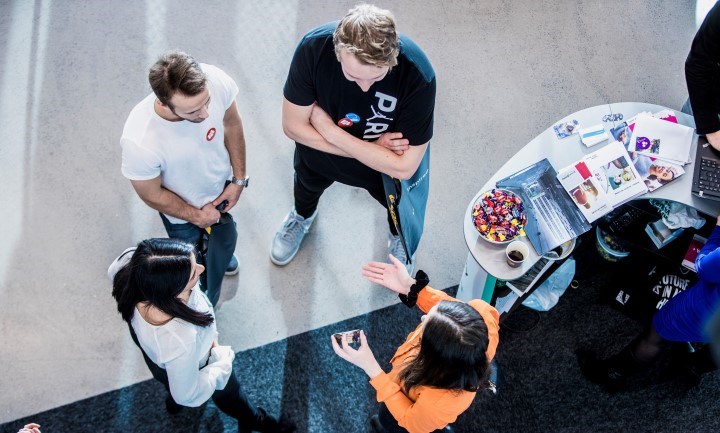 Några studenter samtalar med en utställare.