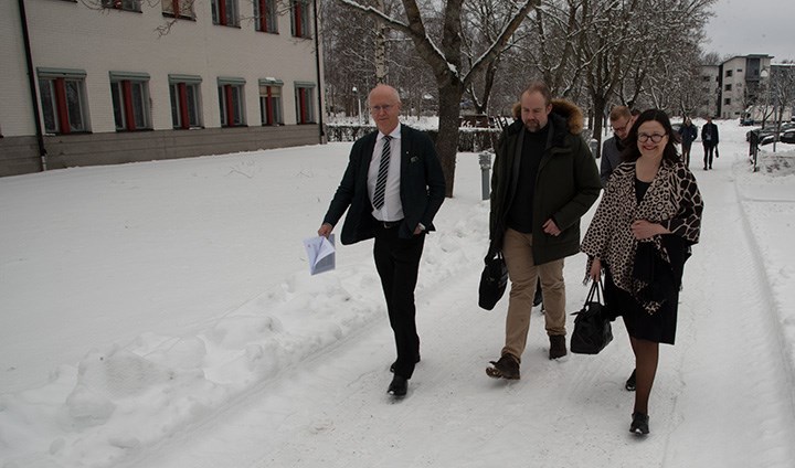 Johan Schnürer, John Johansson ochAnna Ekström går genom ett snöigt campus.
