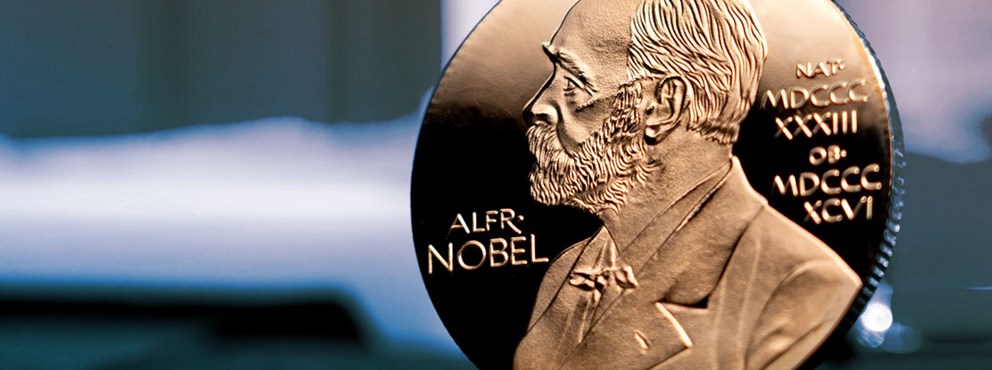 Alfred Nobel-märket i brons mot en bakgrund.