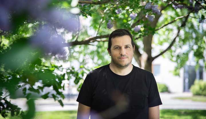 Antonios Valachis utomhus med syrénblommor i förgrunden
