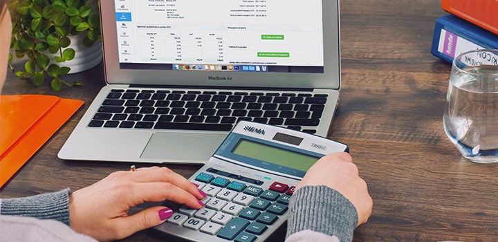 Hands with a calculator and computer.