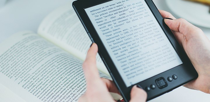 Two hands holding a digital reading device.