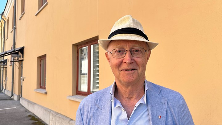 Rektor i vit hatt mor gul vägg