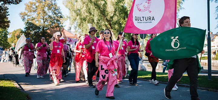 Glada studenter från qultura paraderar i tåg.