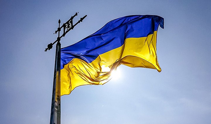 En blågul flagga från Ukraina mot en blå himmel.