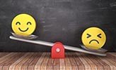 En glad och en arg emoji på en gungbräda