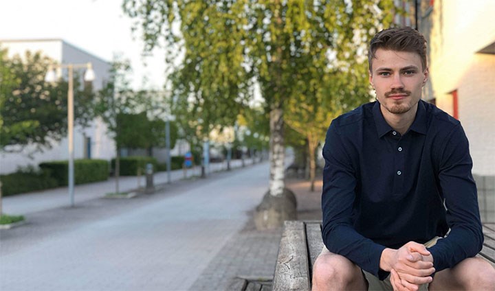 Marcus Gerdin sitter utomhus på campus. 