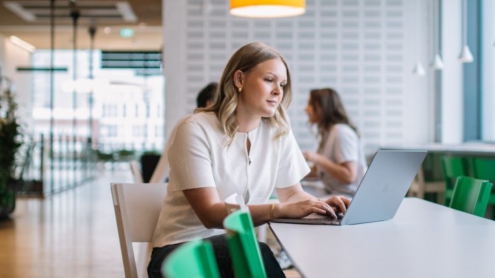 Glad man med skägg framför en laptop.