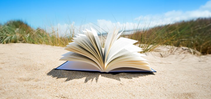 En öppen bok på en solig strand.