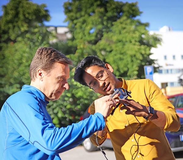 Doctoral student Ravi Chadalavada, on the right, explains to Peter Gullman how eye-tracking glasses work.
