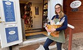 Dominique Prahl Fernandes har en korg med delikatesser i famnen och står utanför sin praktikplats, The House of Taste.