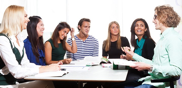 Photo of seven people sitting round a table.