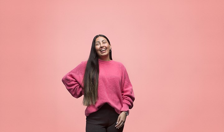En kvinnlig student i rosa ler stort