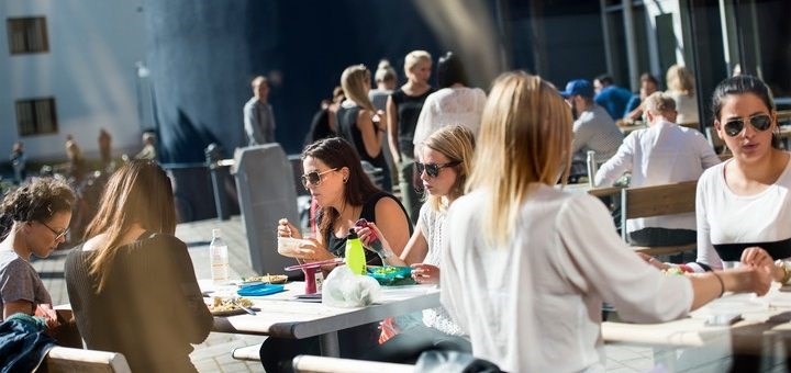 Students sitting outside in the sun on campus.