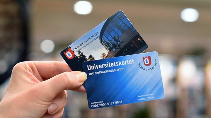 Photo of a hand holding a University Card and a Library card.
