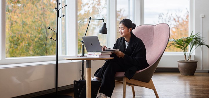 En student sitter och studerar vid sin laptop.