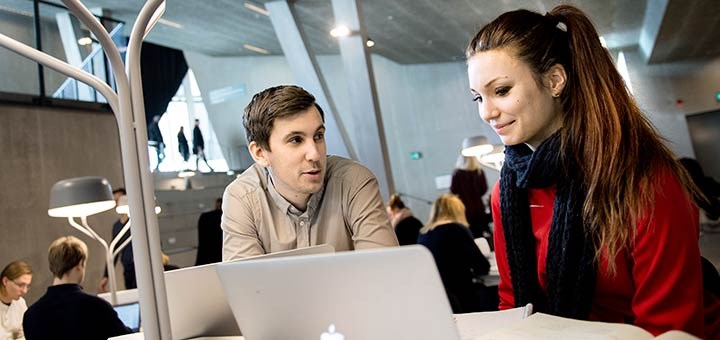 Två studenter vid en bärbar dator.