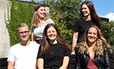 Fem personer som ingår i projektgruppen för introduktionen sitter tillsammans på campus.