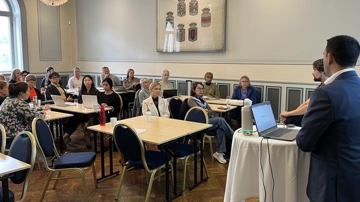 bild på mötesdeltagare i konferensrum.