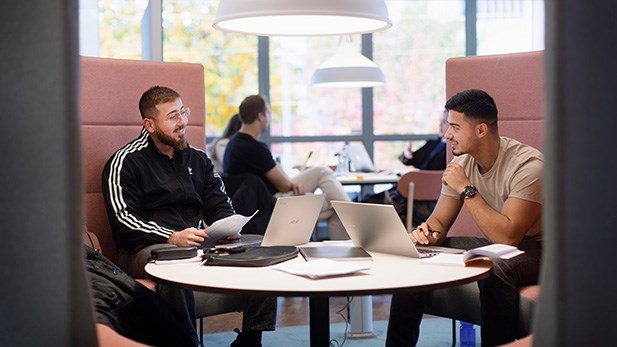 Två studenter sitter och pratar.