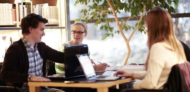 Studenter som sitter i grupp vid ett bord.