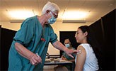 En student får vaccin av en sjuksköterska.
