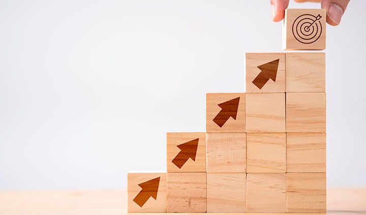 A staircase made of blocks. Arrows lead up the stairs, and at the top there is a target.