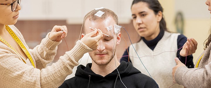 En student mäter sin hjärnaktivitet med sensorer på huvudet.
