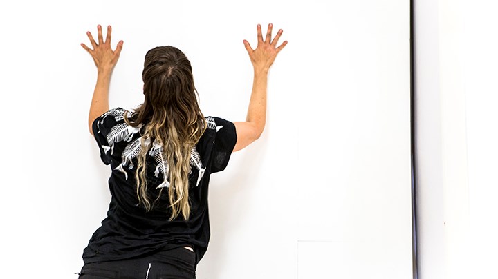 Tove Sahlin står mot en vit vägg