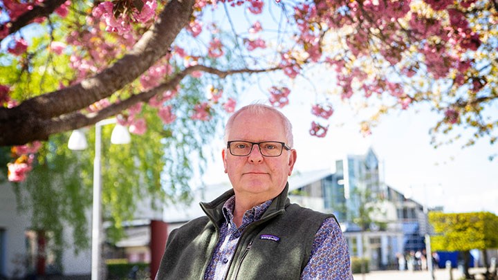Knut Fälker standing beneath cherry blossoms.