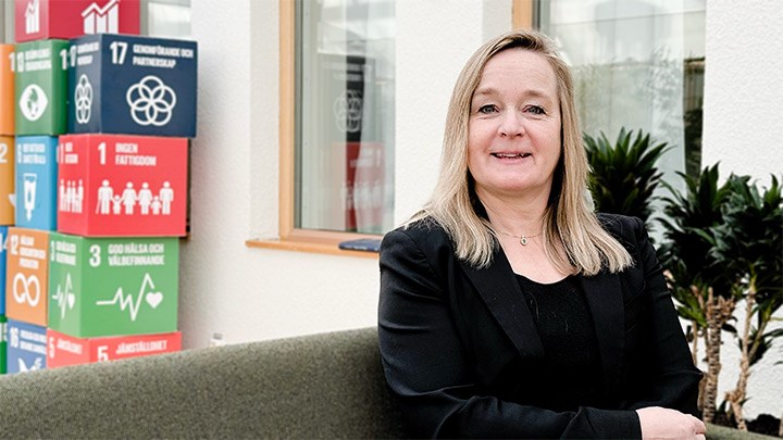 Eleonor Kristoffersson sitting on a sofa with colourful boxes in the background.