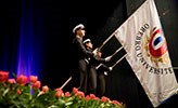 Three people holding Örebro university celebration flags