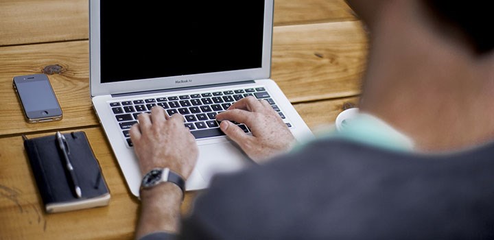 A man typing on a laptop.