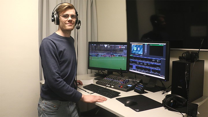 Hampus Gustavsson står i redaktionen för Piteåtidningen vid en dator med dubbla skärmar. 