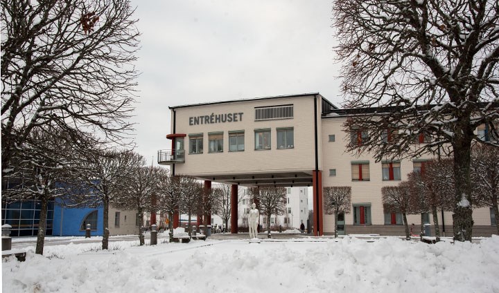 Entréhuset bakom en snöig Krakadamm. 