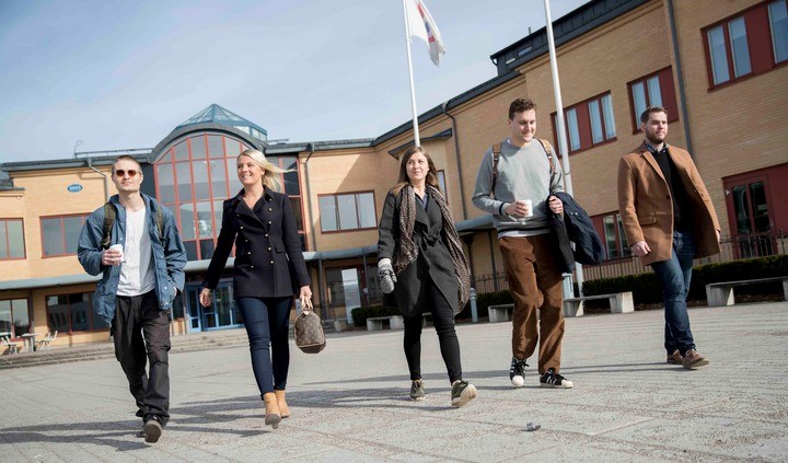 Fyra studenter går bredvid varandra utomhus