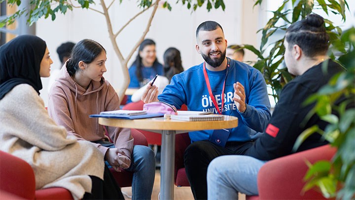 Skolelever och studentambassadörer runt ett bord. 