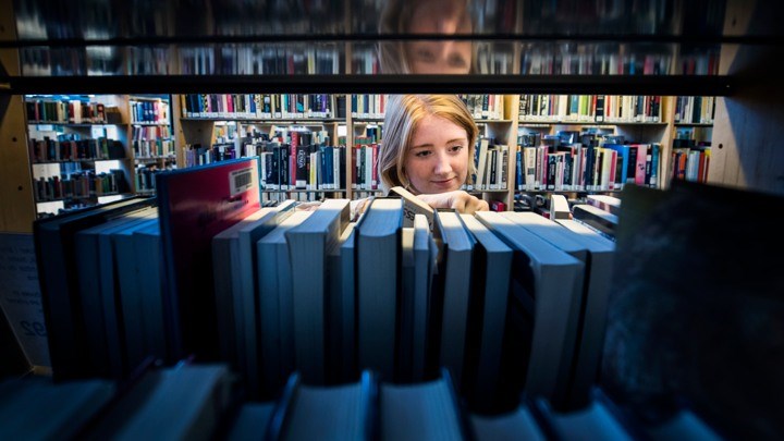 Student browsing the University library shelves