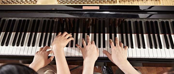 Händer spelar piano.
