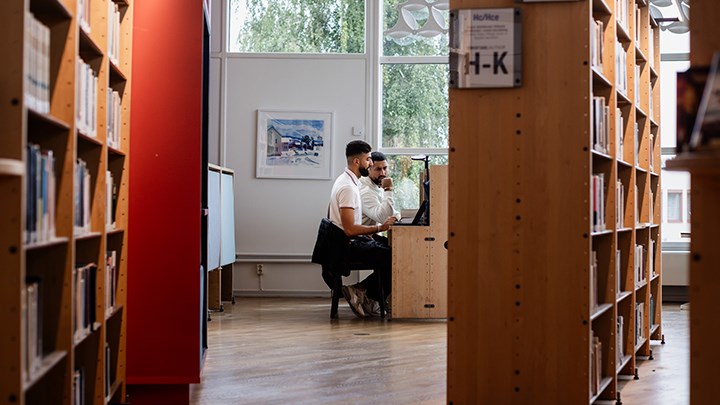 Två studenter som sitter i biblioteket