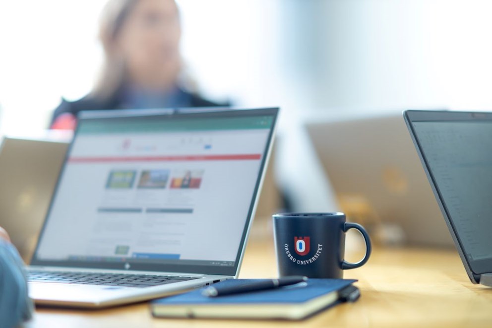 Computer, notebook, pen and mug