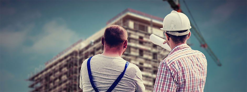 Två män tittar mot platsen där ett nytt hus byggs