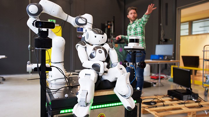 Lagerrobot. Forskaren Martin Magnusson syns i bakgrunden. 