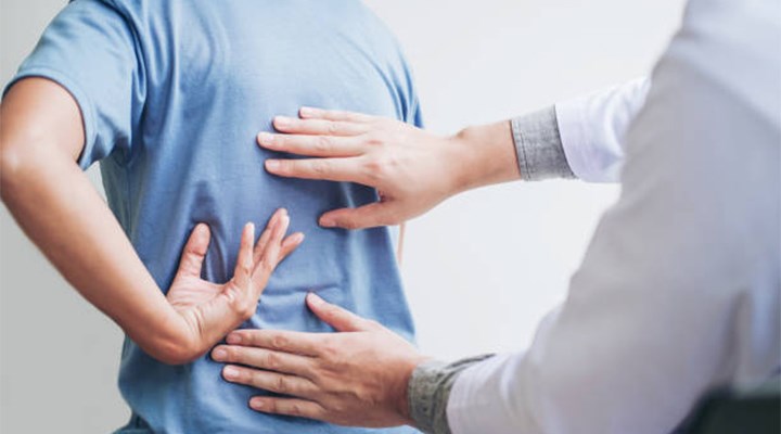  A physiotherapist examines a patient's back.