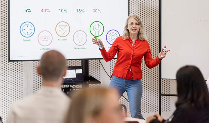 En kvinna och en man diskuterar något framför en dator.