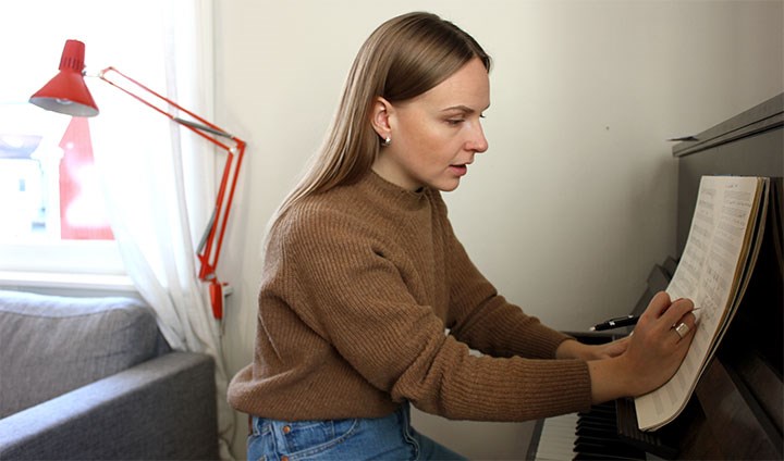 Linnea Landström skriver musik vid sitt piano.